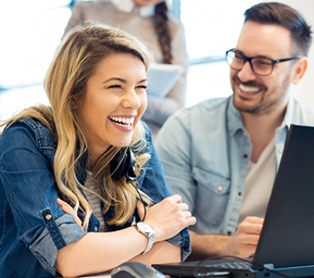 Photo showing a man and woman in from of a computer monitor