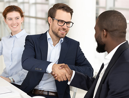 Three people at work shaking hands and showing integrity towards each other