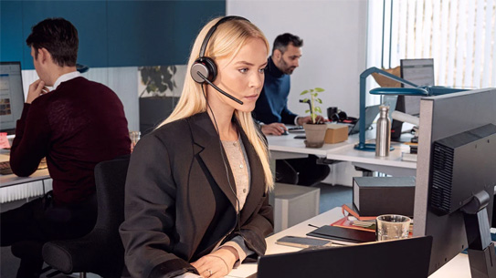 A woman using a new EPOS headset at work