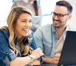 2 people at work smiling and having a good day